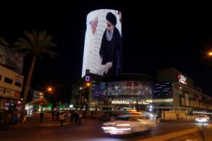 A building is illuminated with a picture of Pope Francis with Iraq’s top Shi’ite cleric, Grand Ayatollah Ali al-Sistani, in Baghdad, Iraq March 7, 2021. REUTERS/Khalid al-Mousily/File Photo