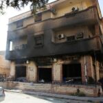 A man stands next to a building burned during clashes in Tripoli, Libya. August 28, 2022. REUTERS/Hazem Ahmed/File Photo