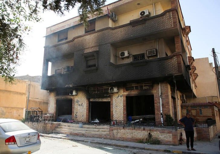 A man stands next to a building burned during clashes in Tripoli, Libya. August 28, 2022. REUTERS/Hazem Ahmed/File Photo