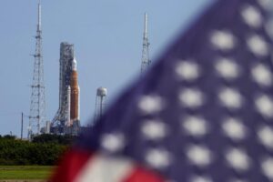 An American flag flies in the breeze as NASA’s new moon rocket sits on Launch Pad 39-B after being scrubbed at the Kennedy Space Center Saturday, Sept. 3, 2022, in Cape Canaveral, Fla. This is scheduled to be the first flight of NASA’s 21st-century moon-exploration program, named Artemis after Apollo’s mythological twin sister. (AP Photo/Chris O’Meara)