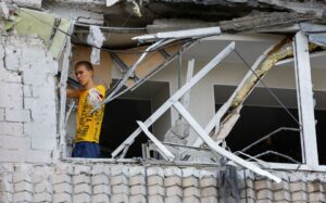 A local resident removes debris inside a multi-storey apartment block damaged by shelling in the course of Ukraine-Russia conflict in the Russian-controlled city of Enerhodar in the Zaporizhzhia region, Ukraine September 1, 2022. REUTERS/Alexander Ermochenko/