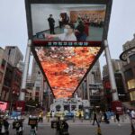 A giant screen shows news footage of Chinese President Xi Jinping visiting Xinjiang Uyghur Autonomous Region, at a shopping centre, in Beijing, China, July 15, 2022. REUTERS/Tingshu Wang/File Photo