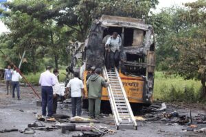 People inspect a bus that caught fire in a highway in Nashik, in the western Indian state of Maharashtra, Saturday, Oct. 8, 2022. The bus caught fire after hitting a truck on a highway in western India early Saturday, killing at least 12 passengers, said police officer Bhagwan Adke. Another 43 people with serious burns were taken to a hospital in Nashik. (AP Photo/Yatish Bhanu)