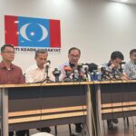 Malaysian opposition leader Anwar Ibrahim, center, speaks during a press conference at his party headquarters in Petaling Jaya, Malaysia, Thursday, Oct. 13, 2022. Anwar says he is optimistic that his opposition alliance is able to strive for a simple majority in general elections expected to be held next month. (AP Photo/Eileen Ng)