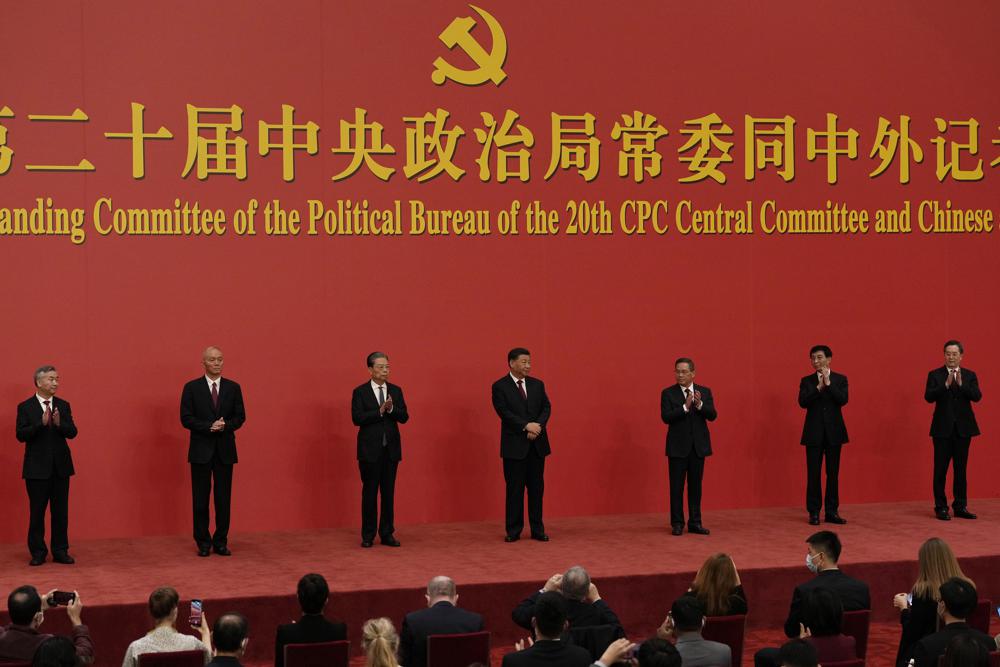 FILE – New members of the Politburo Standing Committee, from left, Li Xi, Cai Qi, Zhao Leji, President Xi Jinping, Li Qiang, Wang Huning, and Ding Xuexiang are introduced at the Great Hall of the People in Beijing on Oct. 23, 2022. The world faces the prospect of more tension with China over trade, security and human rights after Xi Jinping awarded himself a third five-year term on Oct. 23, 2022 as leader of the ruling Communist Party. (AP Photo/Ng Han Guan, File)