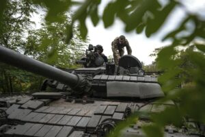 Ukrainian servicemen sit on T-80 tank that they claimed had been captured from the Russian army in Bakhmut, Ukraine, Sunday, Oct. 2, 2022. (AP Photo/Inna Varenytsia)