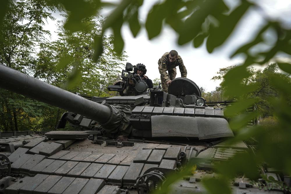 Ukrainian servicemen sit on T-80 tank that they claimed had been captured from the Russian army in Bakhmut, Ukraine, Sunday, Oct. 2, 2022. (AP Photo/Inna Varenytsia)