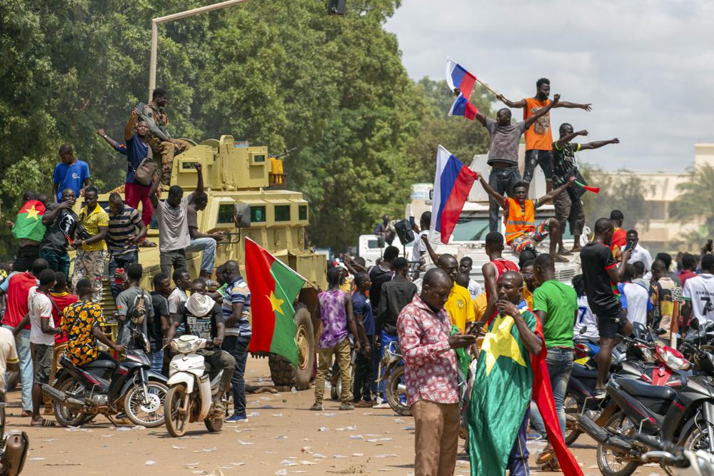 Supporters of Capt. Ibrahim Traore cheer with Russian flags in the streets of Ouagadougou, Burkina Faso, Sunday, Oct. 2, 2022. Burkina Faso’s new junta leadership is calling for calm after the French Embassy and other buildings were attacked. (AP Photo/Kilaye Bationo)
