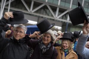 Campaigners take their hat off in a show of respect for people who took their own lives in The Hague, Netherlands, Monday, Oct. 10, 2022, where they calling for the decriminalization of assisted suicide in the Netherlands took the Dutch state to court, arguing its ban breaches human rights norms. The case at The Hague District Court was brought by a group called Cooperative Last Will, which has long urged a change of the law to allow people to help relatives end their lives. (AP Photo/Peter Dejong)
