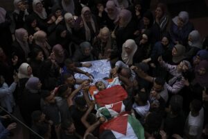 Palestinian mourners carry the body of Fayez Damdoum, during his funeral in the West Bank village of Azariyah, Saturday, Oct. 1, 2022. Israel’s paramilitary border police said forces shot a protester who attempted to throw a firebomb at them as they came to disperse a demonstration. It said demonstrators threw stones and explosives at them. The Palestinian Health Ministry identified the dead youth as 18-year-old Fayez Damdoum. (AP Photo/Mahmoud Illean)