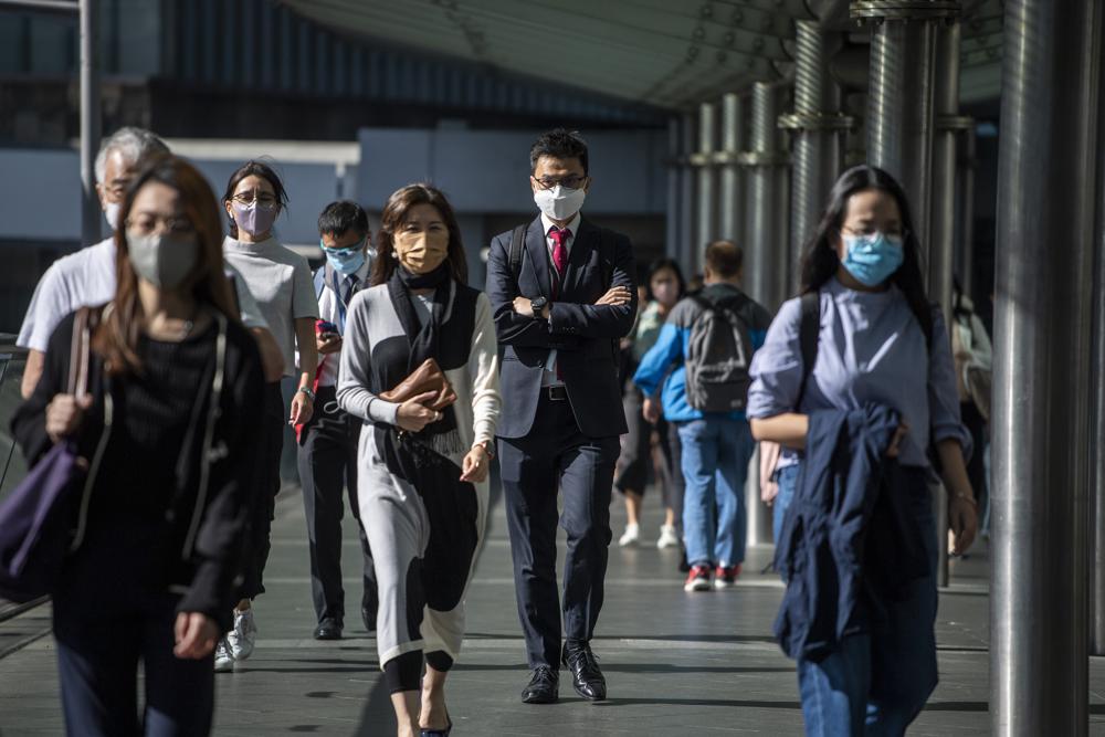 Pedestrians walk on a footbridge in Hong Kong, Wednesday, Oct. 19, 2022. Hong Kong’s leader on Wednesday unveiled a new visa scheme to woo global talent, as the city seeks to stem a brain drain that has risked its status as an international financial center. (AP Photo/Vernon Yuen)
