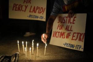 Activists hold a candle beside slogans as they condemn the killing of Filipino journalist Percival Mabasa during a rally in Quezon city, Philippines on Tuesday Oct. 4, 2022. Motorcycle-riding gunmen killed a longtime radio commentator in metropolitan Manila in the latest attack on a member of the media in the Philippines, considered one of the world’s most dangerous countries for journalists. (AP Photo/Aaron Favila)