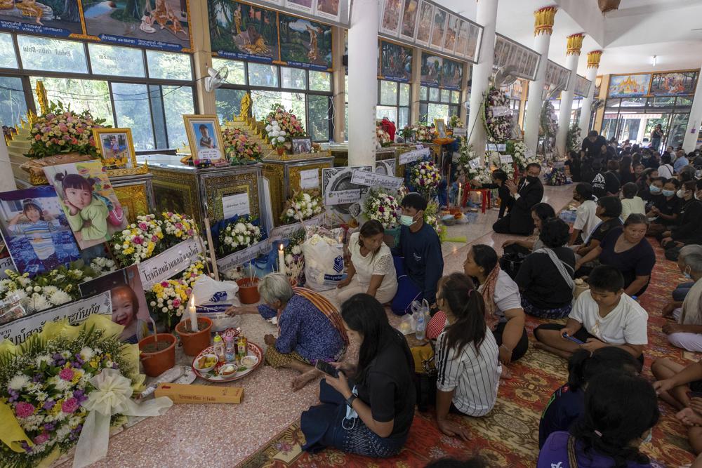 Relatives of the victims of a mass killing attack pray during a Buddhist ceremony at Wat Rat Samakee temple in the rural town of Uthai Sawan, north eastern Thailand, Saturday, Oct. 8, 2022. A former police officer burst into a day care center in northeastern Thailand on Thursday, killing dozens of preschoolers and teachers before shooting more people as he fled. (AP Photo/Wason Wanichakorn)