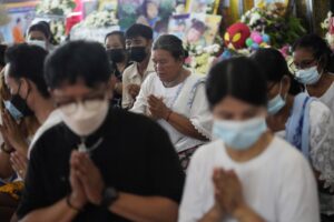 Relatives of the victims of a mass killing attack gather for a Buddhist ceremony Wat Rat Samakee temple in Uthai Sawan, northeastern Thailand, Monday, Oct. 10, 2022. A former police officer facing a drug charge burst through a locked door at a day care center in northeastern Thailand, killing dozens of preschoolers and teachers and then shooting more people as he fled. (AP Photo/Sakchai Lalit)