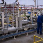 FILE – Operators work at Enagas regasification plant, the largest LNG plant in Europe, in Barcelona, Spain, March 29, 2022. Households and businesses across Europe have been suffering for months from soaring electricity prices, but Iberian countries Spain and Portugal have managed to free themselves from the EU pricing system and Spain says the benefits are noticeable. (AP Photo/Emilio Morenatti, File)