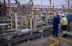 FILE – Operators work at Enagas regasification plant, the largest LNG plant in Europe, in Barcelona, Spain, March 29, 2022. Households and businesses across Europe have been suffering for months from soaring electricity prices, but Iberian countries Spain and Portugal have managed to free themselves from the EU pricing system and Spain says the benefits are noticeable. (AP Photo/Emilio Morenatti, File)