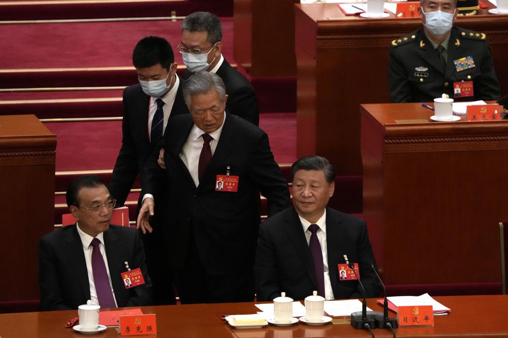 Former President Hu Jintao walks past Chinese President Xi Jinping, right, and Premier Li Keqiang during the closing ceremony of the 20th National Congress of China’s ruling Communist Party at the Great Hall of the People in Beijing, Saturday, Oct. 22, 2022. (AP Photo/Ng Han Guan)