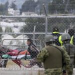 An injured inmate is evacuated in a gurney after a deadly prison riot in Latacunga, Ecuador, Tuesday, Oct. 4, 2022. A clash between inmates armed with guns and knives inside the prison has left at least 15 people dead and 20 injured. (AP Photo/Dolores Ochoa)