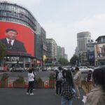 Chinese President Xi Jinping is seen at the end of the Chinese Communist Party’s 20th Party Congress on a giant screen a commercial district of Hangzhou in eastern China’s Zhejiang province on Sunday, Oct 23, 2022. China’s economic growth accelerated in the latest quarter but still was among the slowest in decades as the country wrestled with repeated closures of cities to fight virus outbreaks. (Chinatopix via AP)