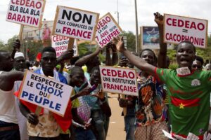 Supporters of Capt. Ibrahim Traore protest against France and the West African regional bloc known as ECOWAS in the streets of Ouagadougou, Burkina Faso, Tuesday, Oct. 4, 2022. A meeting of West African regional mediators stepping up pressure on the country’s new junta comes amid fears that the second coup to hit the country this year will further delay democratic elections and a return to civilian rule. (AP Photo/Kilaye Bationo)