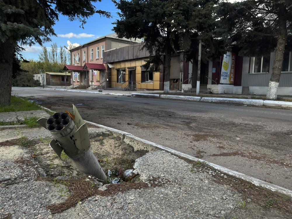 A part of a rocket sits wedged in the ground on a street in the recaptured town of Lyman, Ukraine, Friday, Oct. 7, 2022. Ukrainian authorities are just beginning to sift through the wreckage of the devastated city of Lyman in eastern Ukraine as they assess the humanitarian toll, and possibility of war crimes, from a months-long Russian occupation. (AP Photo/Justin Spike)