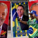 A demonstrator dressed in the colors of the Brazilian flag performs in front of a street vendor’s towels for sale featuring Brazilian presidential candidates, current President Jair Bolsonaro, center, and former President Luiz Inacio Lula da Silva, in Brasilia, Brazil, Tuesday, Sept. 27, 2022. Nearly a dozen candidates are running in Brazil’s presidential election but only two stand a chance of reaching a runoff: former President Luiz Inacio Lula da Silva and incumbent Jair Bolsonaro. (AP Photo/Eraldo Peres)
