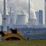 FILE – Steam comes out of the chimneys of the coal-fired power station Neurath near the RWE Garzweiler open-cast coal mine in Luetzerath, Germany, Monday, Oct.25, 2021. German energy giant RWE says it will phase out the burning of coal by 2030, saving 280 million metric tons of climate-changing greenhouse gas emissions. The decision announced Tuesday will accelerate the closure of some of Europe’s most polluting power plants and a vast lignite strip mine in the west of the country. (AP Photo/Michael Probst, File)
