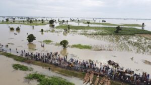 FILE – People walk through floodwaters with flooded farmlands forground after heavy rainfall in Hadeja, Nigeria, Sept 19, 2022. West and Central African countries are battling deadly floods that have upended lives and livelihoods, raising fears of further disruption of food supplies in many areas battling armed conflict. “Above-average rainfall and devastating flooding” have affected 5 million people this year in 19 countries across West and Central Africa, according to a new U.N. World Food Program situation report. (AP Photo, file)