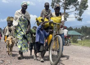Residents flee fighting between M23 rebels and Congolese forces near Kibumba, some 20 kms ( 12 miles) North of Goma, Democratic Republic of Congo, Friday Oct. 28, 2022. Hundreds have been killed and nearly 200,000 people displaced since fighting erupted a year ago. Congo has long accused Rwanda of backing the rebels. (AP Photo/Justin Kabumba)