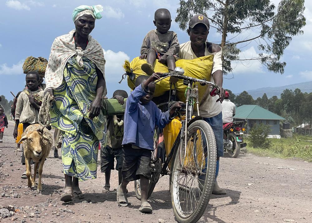 Residents flee fighting between M23 rebels and Congolese forces near Kibumba, some 20 kms ( 12 miles) North of Goma, Democratic Republic of Congo, Friday Oct. 28, 2022. Hundreds have been killed and nearly 200,000 people displaced since fighting erupted a year ago. Congo has long accused Rwanda of backing the rebels. (AP Photo/Justin Kabumba)