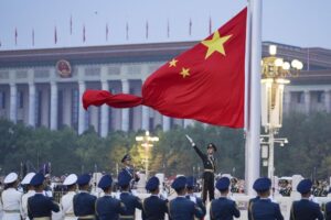 In this photo released by Xinhua News Agency, a member of the Chinese honor guard unfurls the Chinese national flag during a flag raising ceremony to mark the 73rd anniversary of the founding of the People’s Republic of China held at the Tiananmen Square in Beijing on Saturday, Oct. 1, 2022. (Chen Zhonghao/Xinhua via AP)