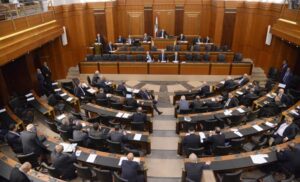 In this photo released by the Lebanese Parliament media office, Lebanese lawmakers and some ministers including Prime Minister Najib Mikati, center, headed by the Parliament Speaker Nabih Berri, top center, attend a parliament session, in Beirut, Lebanon, Tuesday, Oct. 18, 2022. Lebanon’s parliament approved late Tuesday amendments to a banking secrecy law that has been a key demand of the International Monetary Fund amid the country’s historic economic meltdown. (Hassan Ibrahim/Lebanese Parliament media office via AP)