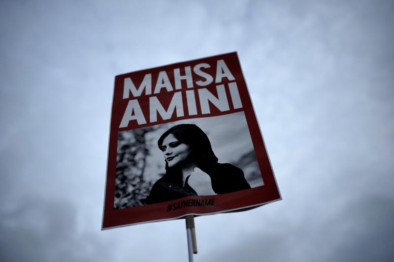FILE – A woman holds a placard with a picture of Iranian woman Mahsa Amini during a protest against her death, in Berlin, Germany, Wednesday, Sept. 28, 2022. Iranian celebrities have been startlingly public in their support for the massive anti-government protests shaking their country. And the ruling establishment is lashing back. Celebrities have found themselves targeted for arrest, have had passports confiscated and faced other harassment. (AP Photo/Markus Schreiber, File)