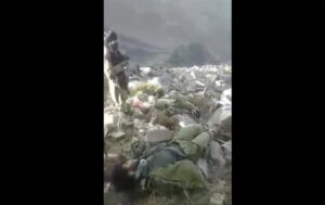 In this frame grab from video that was likely taken by the Taliban and posted online and provided by Afghan Witness, a UK-based open-source nonprofit, a Taliban fighter stands amid bodies on the ground, in the Dara district, of Panjshir province, Afghanistan, Sept. 14, 2022. The Taliban captured, bound and shot to death 27 men in Afghanistan’s Panjshir Valley last month during an offensive against resistance fighters in the area, according to a new report by Afghan Witness published Tuesday, Oct. 18, 2022 refuting the group’s earlier claims that the men were killed in battle. (Afghan Witness via AP)