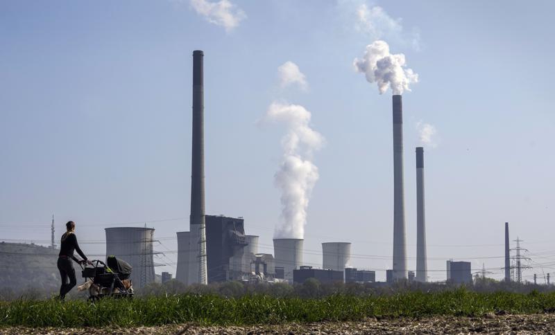 FILE – A mother pushes a stroller in front of the Scholven coal-fired power station, owned by Uniper, in Gelsenkirchen, Germany, March 28, 2022. The world remains “far behind” and is not doing nearly enough to reach any of the global goals limiting future warming, a United Nations report said. (AP Photo/Martin Meissner, File)
