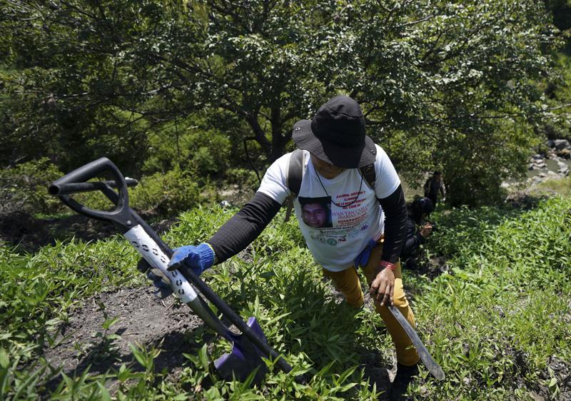 FILE – A relative wearing a T-Shirt with an image of a disappeared boy, inspects an area where the group suspects there are interred bodies of missing persons, just outside of Cuautla, Mexico, Tuesday, Oct. 12, 2021. Activists said Tuesday, Oct. 4, 2022, that Esmeralda Gallardo, who led efforts to find her missing 22-year-old daughter, was killed in Mexico, the fourth murder of a volunteer search activist in Mexico since the start of 2021. (AP Photo/Fernando Llano, File)