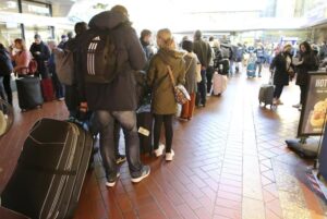 Travelers stand in long lines at the travel center in Hamburg Central Station after long-distance services in northern Germany came to a standstill, Hamburg, Germany, Saturday, Oct.8, 2022. According to Deutsche Bahn, a technical fault in northern Germany is currently causing a complete standstill in long-distance services. All ICE as well as IC and EC trains in northern Germany are affected, (Bodo Marks/dpa via AP)