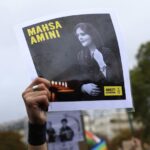 FILE – A protester shows a portrait of Mahsa Amini during a demonstration to support Iranian protesters standing up to their leadership over the death of a young woman in police custody, Sunday, Oct. 2, 2022 in Paris. Anti-government demonstrations erupted Saturday, Oct. 8, in several locations across Iran as the most sustained protests in years against a deeply entrenched theocracy entered their fourth week. The protests erupted Sept. 17, after the burial of 22-year-old Amini, a Kurdish woman who had died in the custody of Iran’s feared morality police. (AP Photo/Aurelien Morissard)