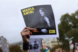 FILE – A protester shows a portrait of Mahsa Amini during a demonstration to support Iranian protesters standing up to their leadership over the death of a young woman in police custody, Sunday, Oct. 2, 2022 in Paris. Anti-government demonstrations erupted Saturday, Oct. 8, in several locations across Iran as the most sustained protests in years against a deeply entrenched theocracy entered their fourth week. The protests erupted Sept. 17, after the burial of 22-year-old Amini, a Kurdish woman who had died in the custody of Iran’s feared morality police. (AP Photo/Aurelien Morissard)