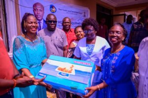 Mrs Divine Iniovosa, Vice Chairman of Warri South, (2nd left) presenting the equipment to Dr Oritsematosan Sagay, the Executive Secretary, Primary Health care Authority, Warri South, while others look on