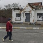 A woman passes an apartment building destroyed by fighting, in the village of Moshun, outside Kyiv, Ukraine, Friday, Nov. 4, 2022. Moschun was hard-hit at the start of the war, approximately 37 people were killed, — among a population of about 1,000 — and 160 homes were completely destroyed, say residents. The town was occupied by Russian troops for nearly six weeks. (AP Photo/Andrew Kravchenko)