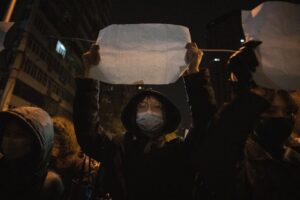 A protestor holds up a blank paper and chant slogans during a march in protest in Beijing, Sunday, Nov. 27, 2022. Protesters angered by strict anti-virus measures called for China’s powerful leader to resign, an unprecedented rebuke as authorities in at least eight cities struggled to suppress demonstrations Sunday that represent a rare direct challenge to the ruling Communist Party. (AP Photo/Ng Han Guan)