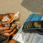 Mobile Point of Sale (POS) operator counts money on Nnamdi Azikwe Street, Lagos Island, Nigeria on 6th January, 2022