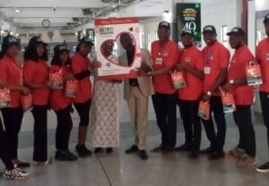 Faan-official-bearing-gifts-in-a-picture-with-a-passenger-e1676454974417