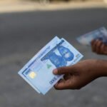 A person holds a new 1000 Naira note as the Central Bank of Nigeria releases the notes to the public through the banks in Abuja