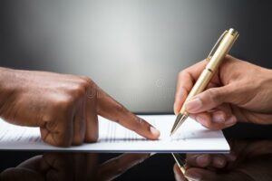 person-signing-document-pointing-finger-front-golden-pen-126325287