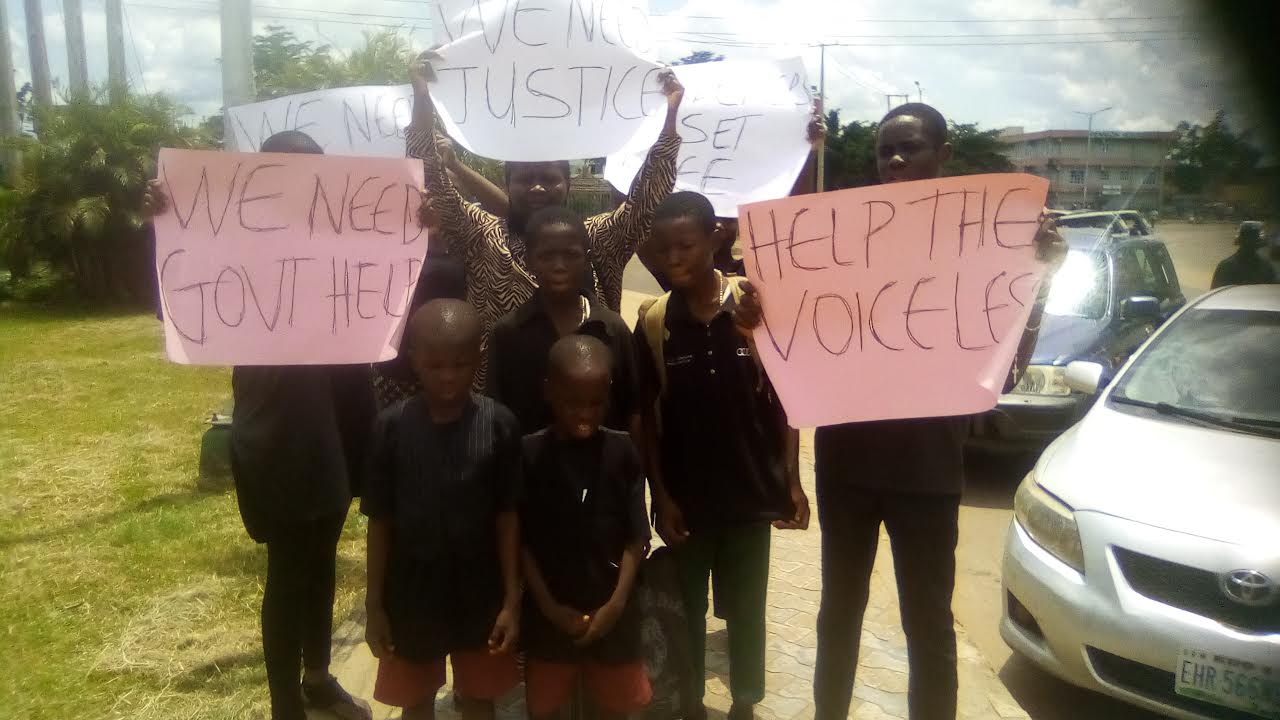 Children, wife and sister of the deceased during the protest in Benin City
