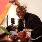 Nduka Otiono with a copy of the award-winning book