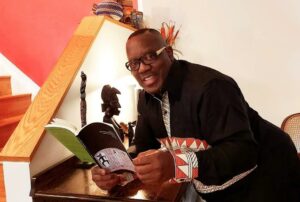 Nduka Otiono with a copy of the award-winning book