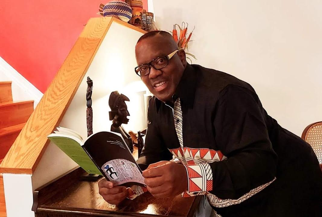 Nduka Otiono with a copy of the award-winning book